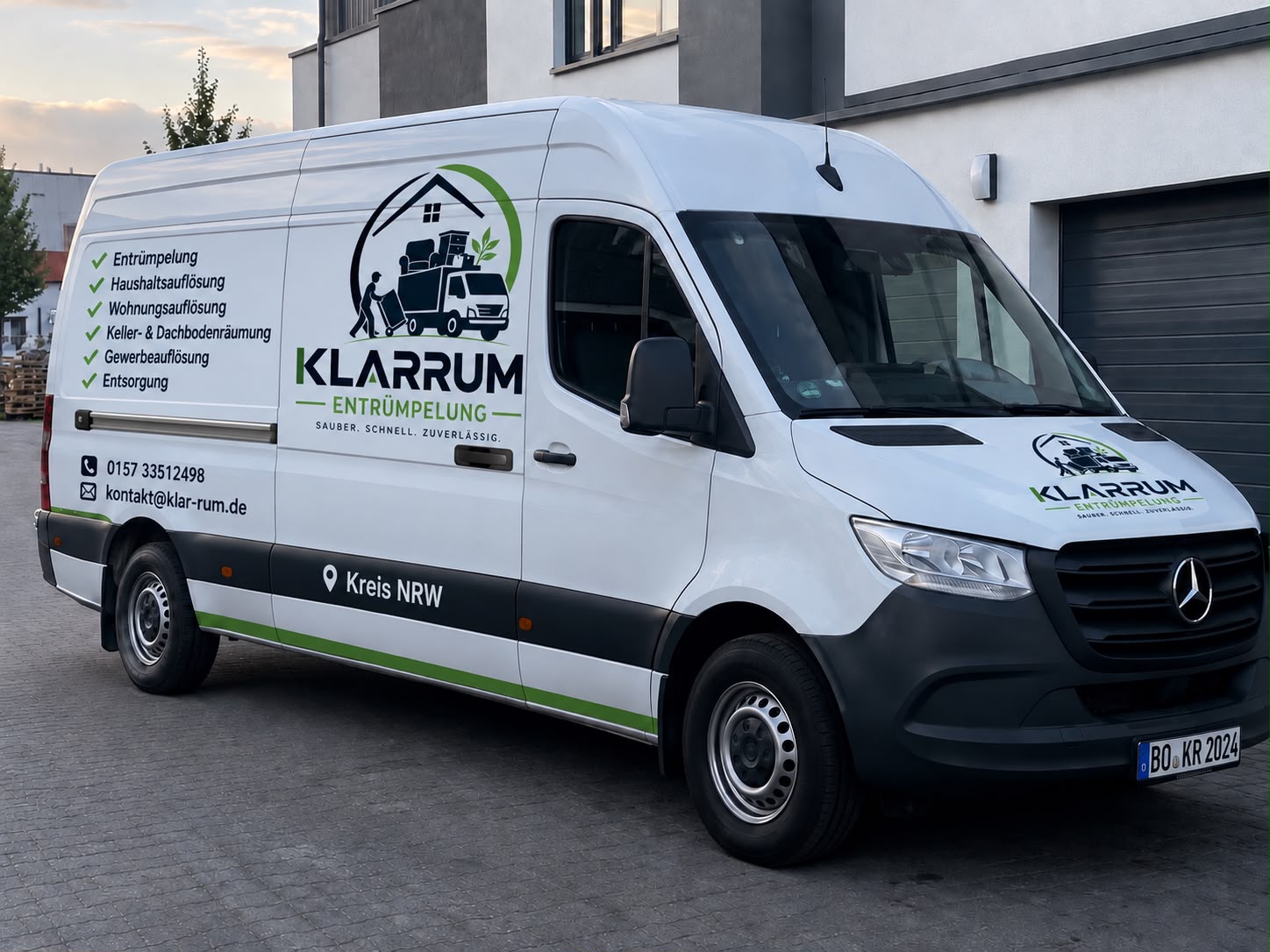 Weißer Transporter von Klarrum Entrümpelung mit Logo und Leistungen auf der Seite